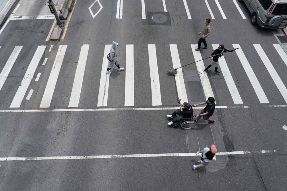 iPhone體積小巧輕便 拍攝過馬路鏡頭不需封街或架設地面滑輪 廖明毅直接坐輪椅和林柏宏一起過紅綠燈